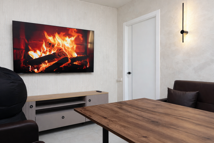 Quest Lounge — светлая комната с диванами, столом и большим экраном
