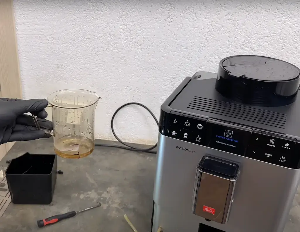 Мерный стакан с 50 мл воды на фоне кофемашины Melitta